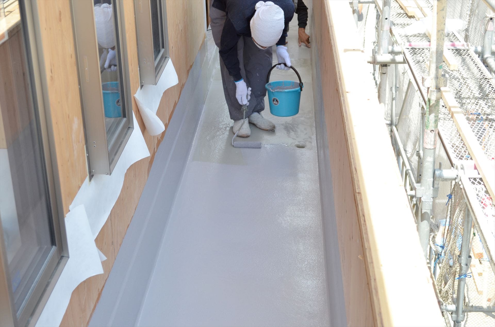 ベランダ床の防水工事を行う職人jpg (1)